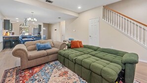 A living room with a sofa, a coffee table, and a rug. - Spacious Home + Hot tub + Fire Pit + Play Loft (Cedar Park)