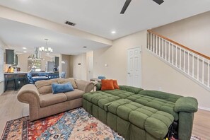 A living room with a sofa, a coffee table, and a rug. - Spacious Home + Hot tub + Fire Pit + Play Loft (Cedar Park)