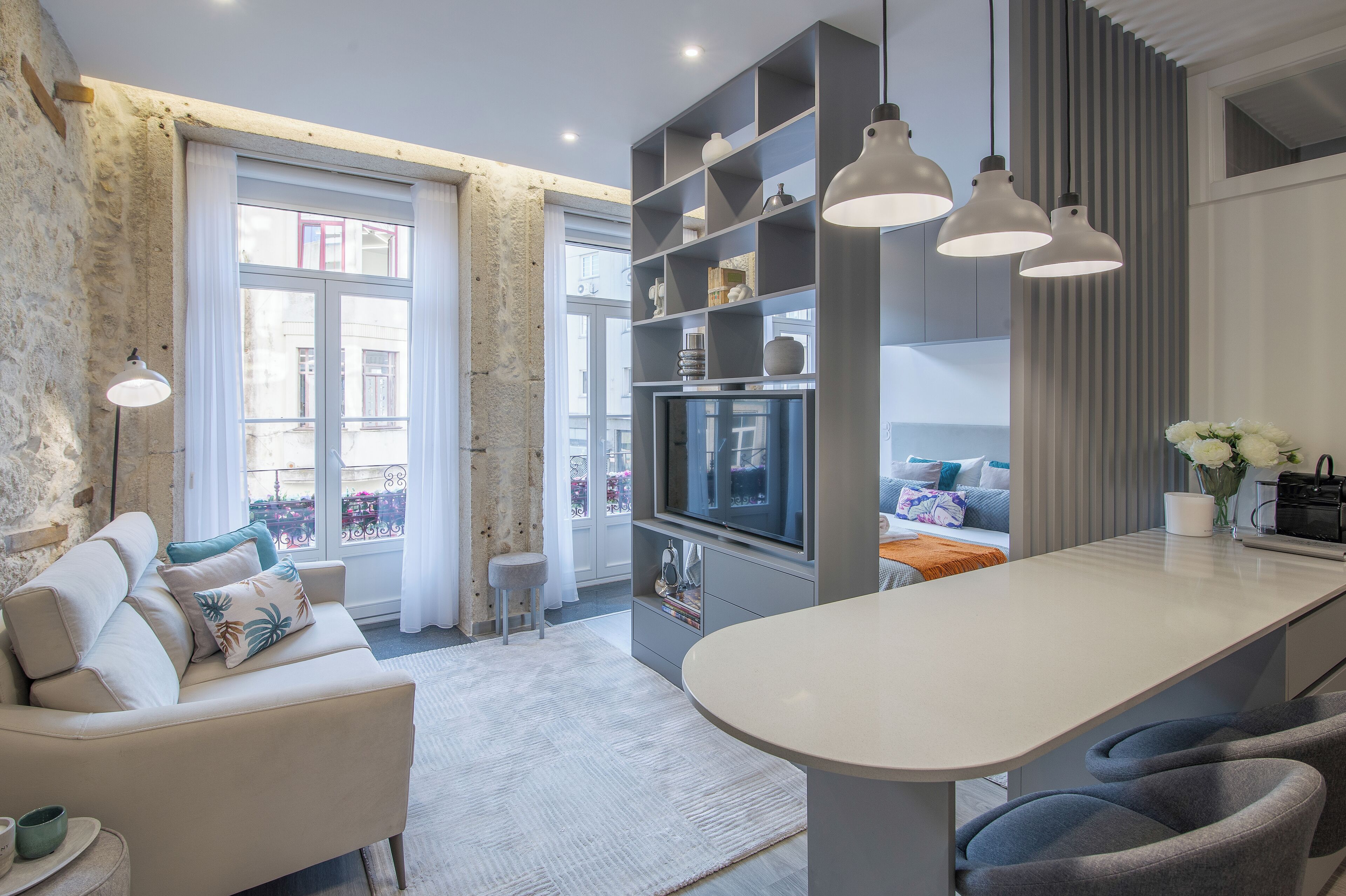 A modern living room with a sofa, TV, and built-in shelves.