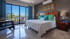 A hotel room with a bed, desk, and chair, large windows, and an air conditioning unit. - Private pool rooftop and BBQ, Malecon 5 min walk (La Paz)