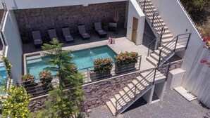 A rooftop pool with lounge chairs, a staircase, and a stone wall. - Private pool rooftop and BBQ, Malecon 5 min walk (La Paz)