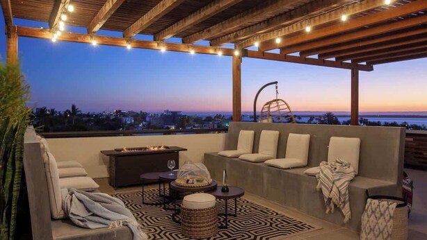 A rooftop patio with a fire pit, seating, and string lights. - Private pool rooftop and BBQ, Malecon 5 min walk (La Paz)