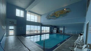 Ein Innenpool mit freiem Blick auf den Ozean, einer Rettungswache und einer Sitzgelegenheit mit Stühlen.