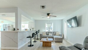 Una sala de estar moderna con un sofá, una mesa de centro y un televisor montado en la pared.