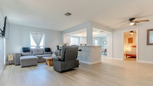 Una sala de estar moderna con un sofá seccional gris, un sillón reclinable gris y una mesa de centro de madera.
