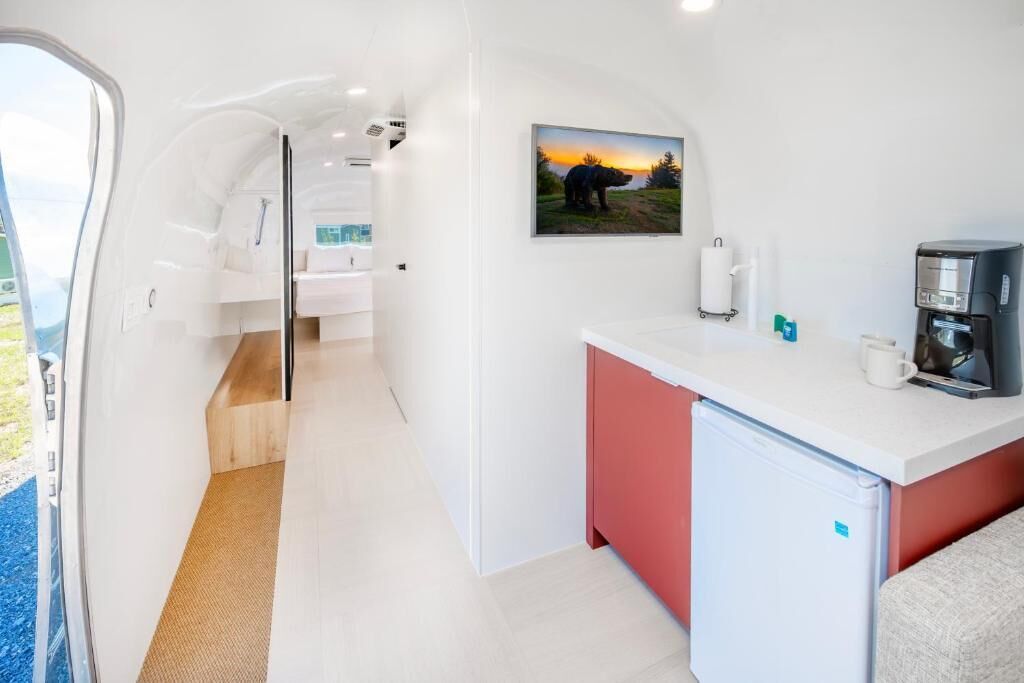 A compact kitchen with a refrigerator, a coffee maker, and a sink.
