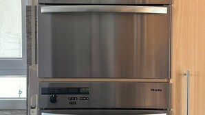Cocina con horno doble y microondas, integrados en armarios de madera.