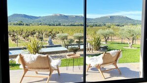 A room with a large window overlooking a vineyard and mountains. - Villa César "a haven of peace with breathtaking views (Chusclan)