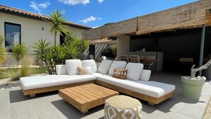 A modern outdoor seating area with a sectional sofa, wooden coffee table, and potted plants. - Villa César "a haven of peace with breathtaking views (Chusclan)