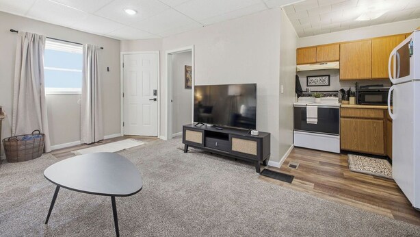 A compact living space with a television, kitchenette, and a dining area. - Cozy 1-bedroom apartment in peaceful Wathena with AC (Wathena)
