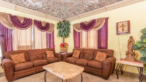 A living room with two brown sofas, a coffee table, and a statue on a side table. - Cozy, Quiet & Beautiful Home Borracho Flat (Bahía la Choya)