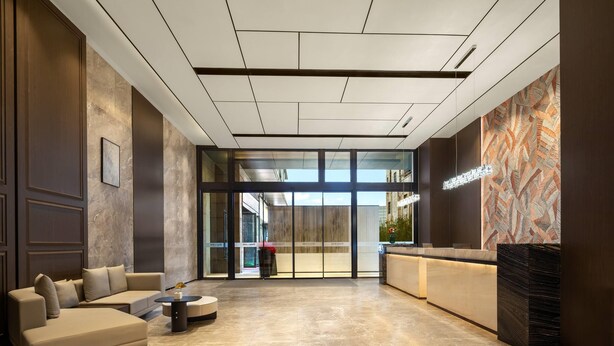 A modern lobby with a reception desk, a sofa, and a coffee table.