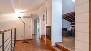A modern interior with a wooden floor, a staircase, a sofa, and a fireplace. - Chica's Luxury Loft in the Heart of Lucca's Historic Center (Lucca)