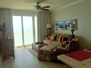 Ein Wohnzimmer mit Sofa, Hocker, Couchtisch und Deckenventilator.