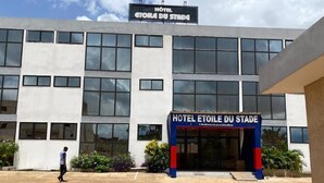 Un bâtiment d’hôtel avec une enseigne indiquant « HOTEL ETOILE DU STADE » et « HOTEL ETOILE DU STADE » en français.