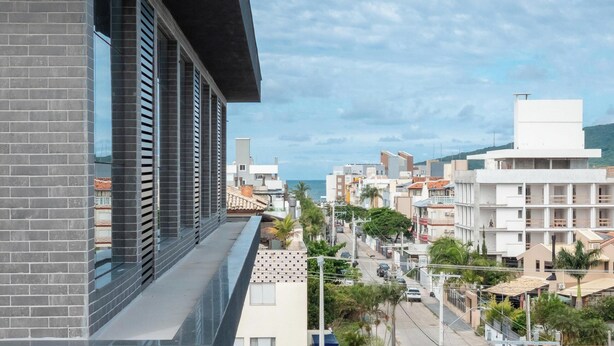 A modern building with large windows, a balcony, and a view of the sea. - Apts in a Condominium w/ Pool Just 500 m fr Ingleses Beach - Mncs (Florianópolis)