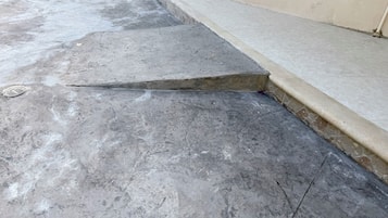 A concrete floor with a visible crack and a drain cover.