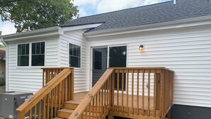 A two-story house with a wooden deck and a small staircase leading to the entrance. - Cute & Cozy 2 Bdrm Getaway  Close to Downtown (Greer)