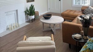 A living room with a fireplace, a ceiling fan, a round table, and a sofa. - Cute & Cozy 2 Bdrm Getaway  Close to Downtown (Greer)