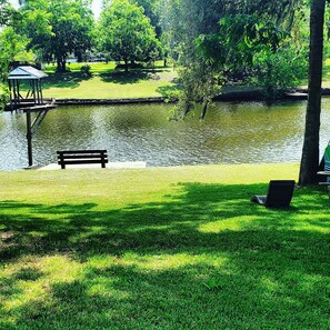 A park with a pond, a bench, and a gazebo.