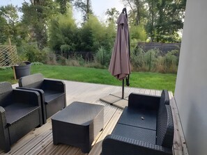 A patio with wicker furniture, a pergola, and a view of a grassy yard. - Holiday Home 'Logis Des 2 Chênes' with Private Terrace, Private Garden and Wi-Fi (Forges-les-Eaux)