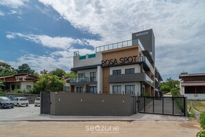 Un edificio de varios pisos con un cartel que dice 'ROSA SPOT' y 'seazone' en la fachada.