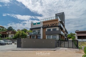 Un edificio de varios pisos con un cartel que dice 'ROSA SPOT' y 'seazone' en la fachada.
