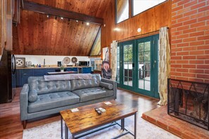 A cozy living room with a leather sofa, wooden coffee table, and a fireplace.