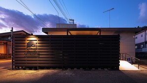 Un bâtiment doté d’un toit en pente, d’une rampe menant à l’entrée et d’une enseigne avec un logo.