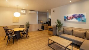 Un salon moderne comprenant une table à manger, des chaises, un canapé, une table basse et un tableau accroché au mur.