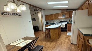 A kitchen with wooden cabinets, a central island, and a dining area with a bench.