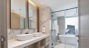 A modern bathroom with two sinks, a glass shower enclosure, and a large bathtub. - Emaar Residences with Direct Access to Marina Mall. (Dubai)