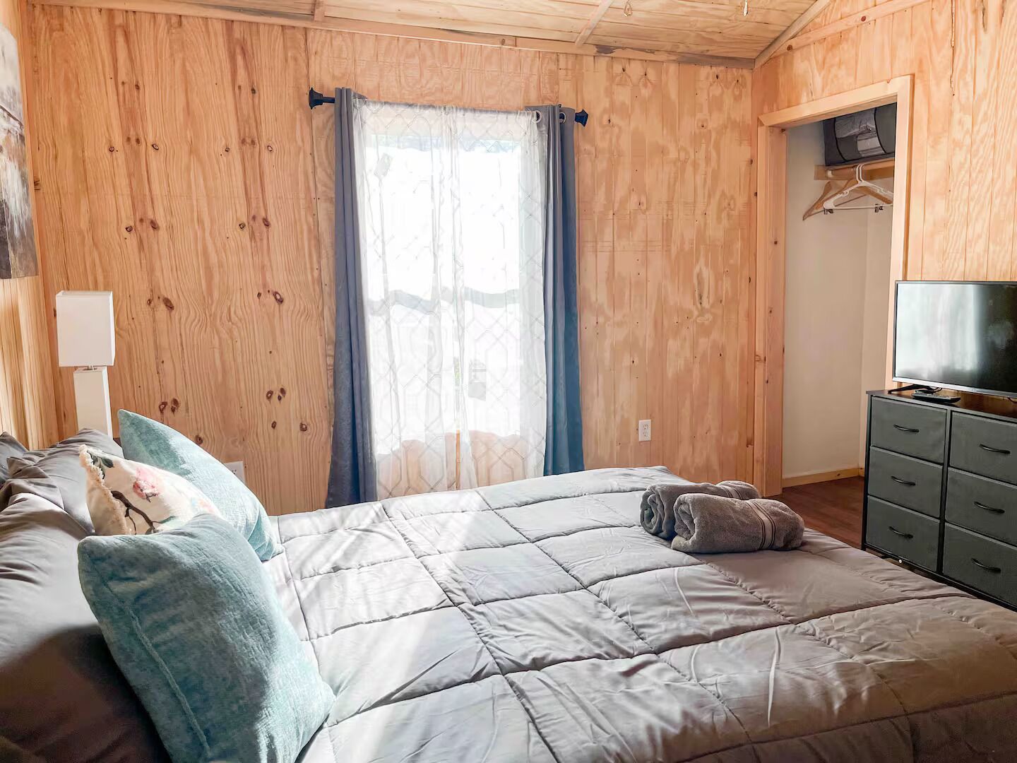 Ein Schlafzimmer mit einem Bett, einem Fernseher und einem Kleiderschrank.