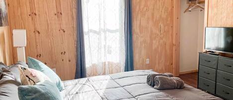 Ein Schlafzimmer mit einem Bett, einem Fernseher und einem Kleiderschrank.