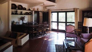 Un salón amplio con una mesa de comedor, sillas, un sofá y una chimenea.