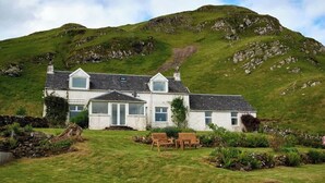 A white house with a sloped roof, a front porch, and a stone wall. - Private Loch-side escape in the Scottish highlands (Oban)