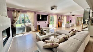 Een moderne woonkamer met een bank, salontafel en een open haard.