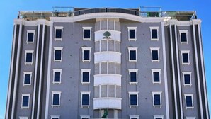 A multi-story hotel with a central entrance, balconies, and a clear sky. - Pearly Hotel (Abha)