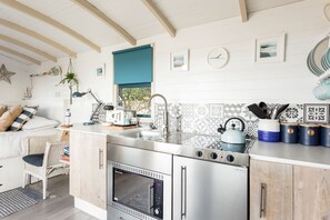 A modern kitchen with stainless steel appliances, a sink, and a window.