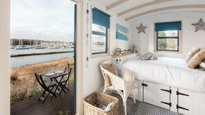 Un dormitorio con cama, escritorio y vista a un puerto deportivo.