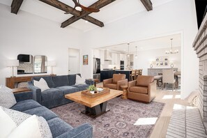 Ein geräumiges Wohnzimmer mit einer großen Couch, einem Couchtisch und einem Essbereich mit Stühlen und einem Tisch.