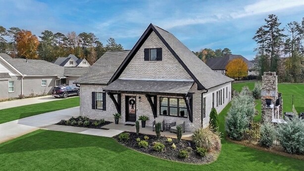 A single-story house with a gabled roof, a front porch, and a stone chimney. - New Gameday Getaway AU Club Home: 3BR + Outdoor Living (Auburn)