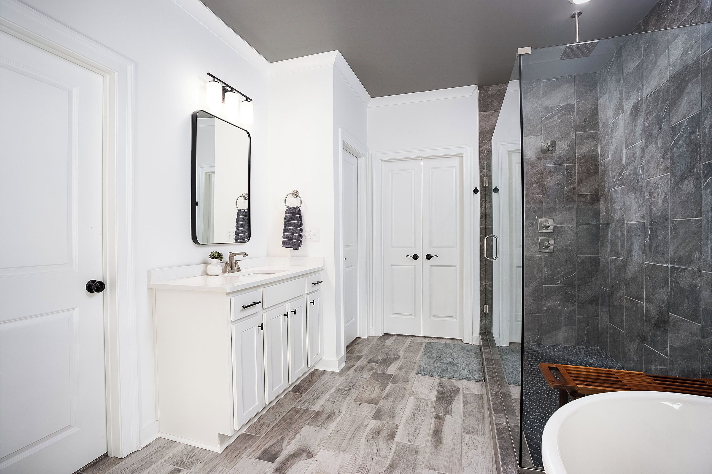 Une salle de bain moderne avec une douche, un lavabo et un miroir.