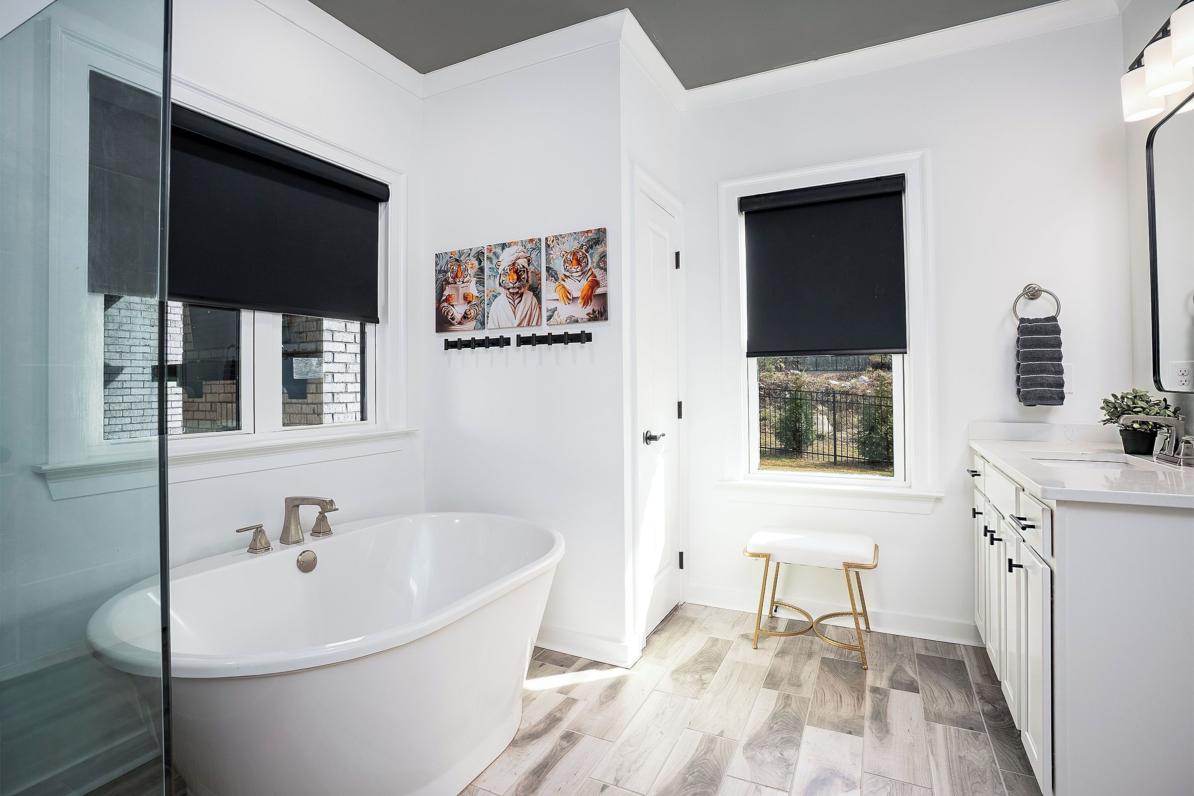 A modern bathroom with a freestanding bathtub, a window with a view, a sink, and a toilet.
