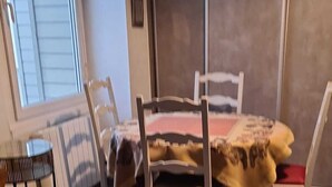 A room with a bed, a chair, a small table, and a window. - Comfortable apartment in private property overlooking flower garden (Lys-Haut-Layon)