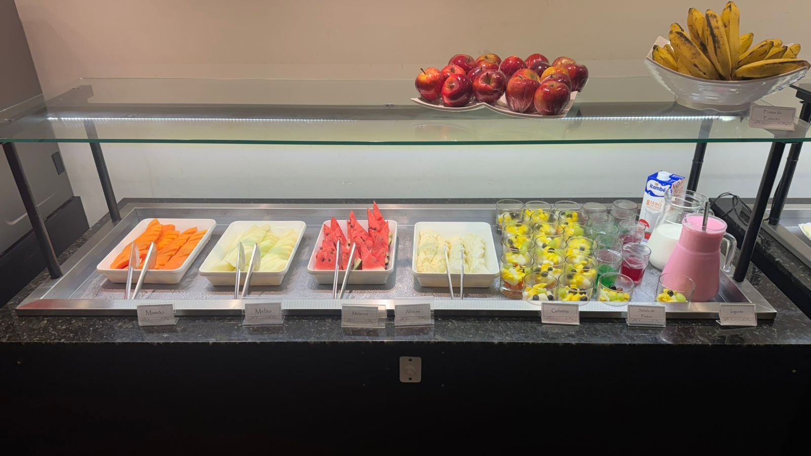 A buffet with various food items and a glass display case above.