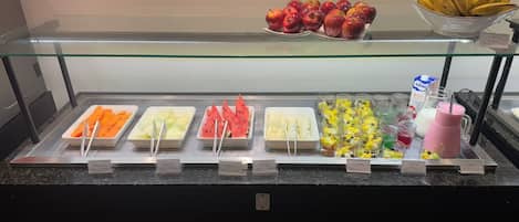Un buffet proposant une variété de plats, avec une vitrine en verre au-dessus.