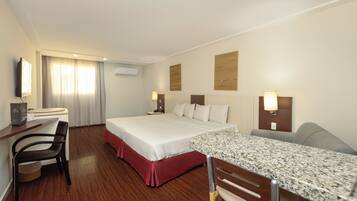 A hotel room with a bed, desk, chair, and a television.