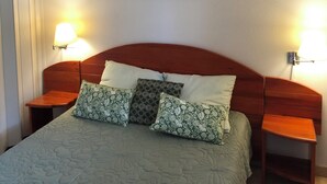 A bedroom with a bed, two bedside tables, a wall-mounted lamp, and a ceiling light fixture. - Appt T4 Residence Le Cordouan 3* pool side (Soulac-sur-Mer)