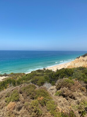 A coastal landscape with a beach, clear sky, and dense vegetation. - Holiday Home 'Celestial Melides Country House' with Private Pool, Private Terrace and Wi-Fi (Melides)